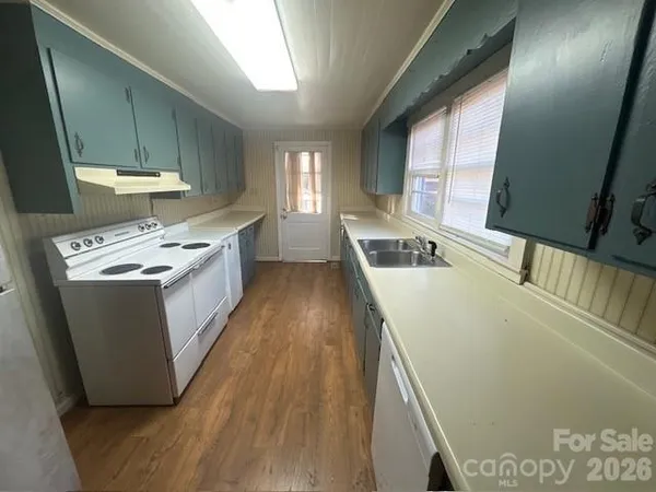 a kitchen with stainless steel appliances granite countertop a sink a stove and a refrigerator