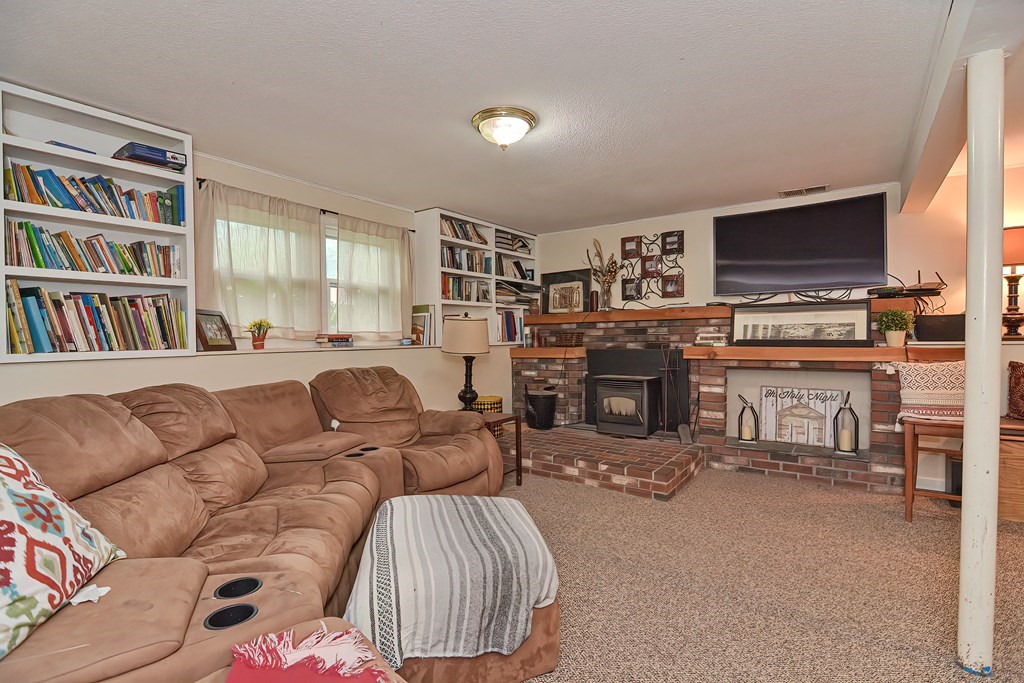23 Carpenter Road Northbridge, MA 01588 - Photo 33 of 38 a living room with furniture a fireplace and a flat screen tv