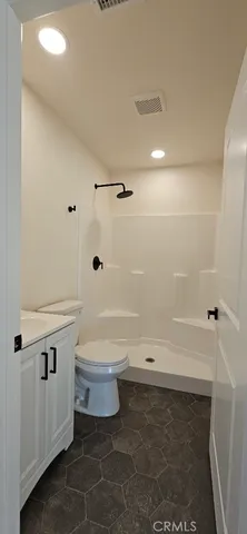 a bathroom with a toilet and a shower