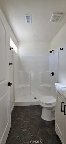 a bathroom with a toilet and a shower
