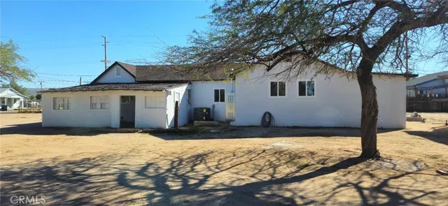 a front view of a house with a yard covered with snow