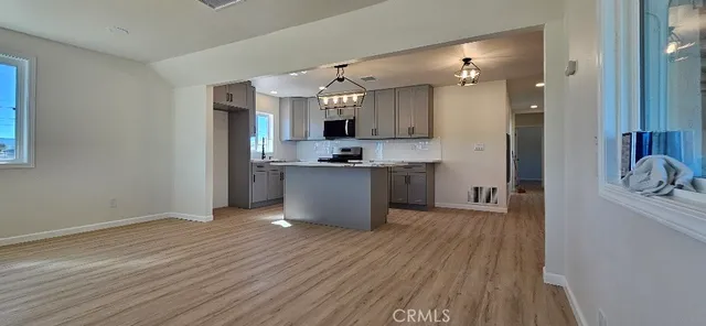 a kitchen with stainless steel appliances granite countertop a hardwood floor sink stove and granite counter top
