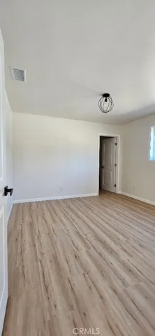 a view of an empty room and wooden floor