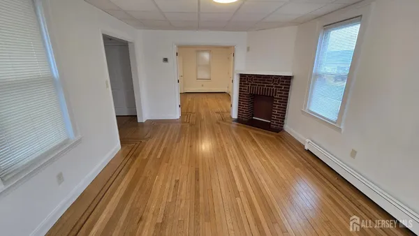 a view of a hallway with wooden floor and a fireplace