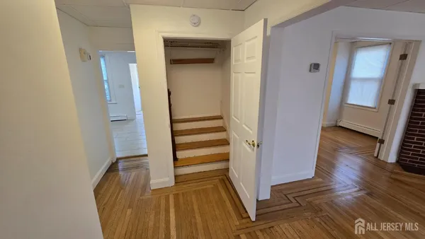 a view of a hallway with wooden floor and staircase