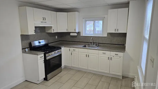 a kitchen with granite countertop white cabinets and white appliances