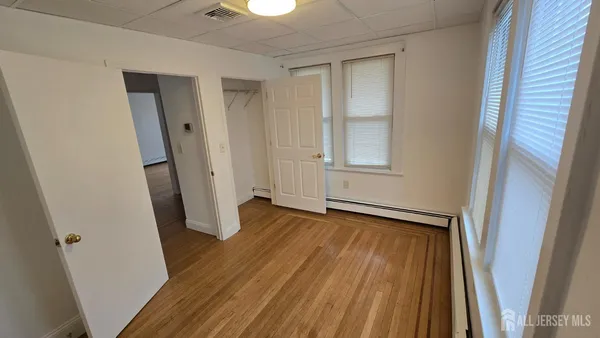 an empty room with wooden floor and entrance