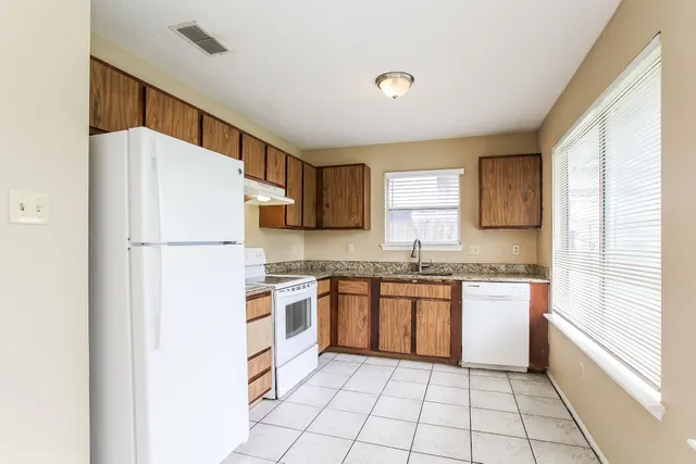 a kitchen with stainless steel appliances granite countertop a refrigerator sink and stove