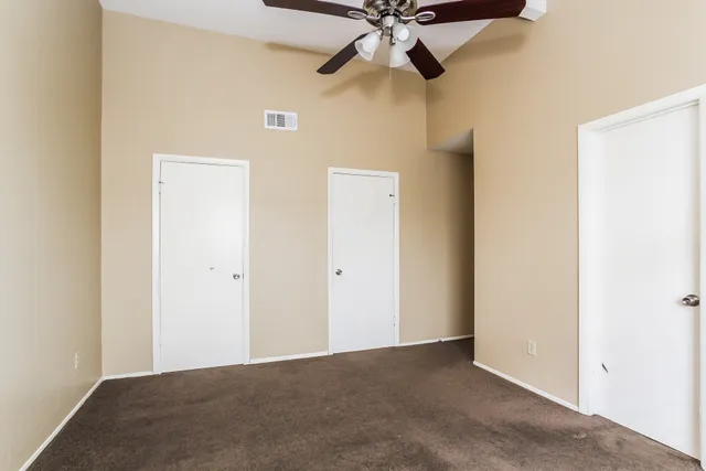 an empty room with a fan and a fan