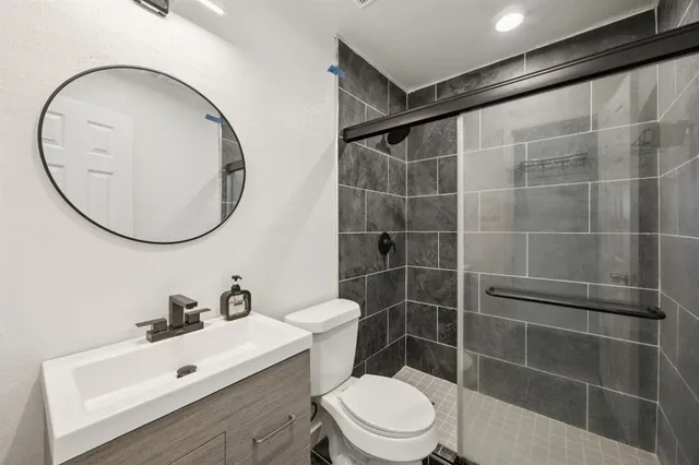 a bathroom with a sink a toilet and a mirror