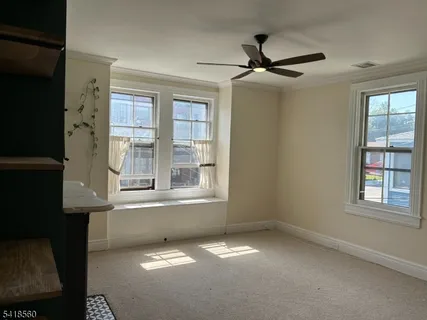 an empty room with windows and fan