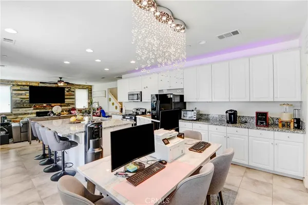 a room with stainless steel appliances kitchen island granite countertop a dining table and chairs