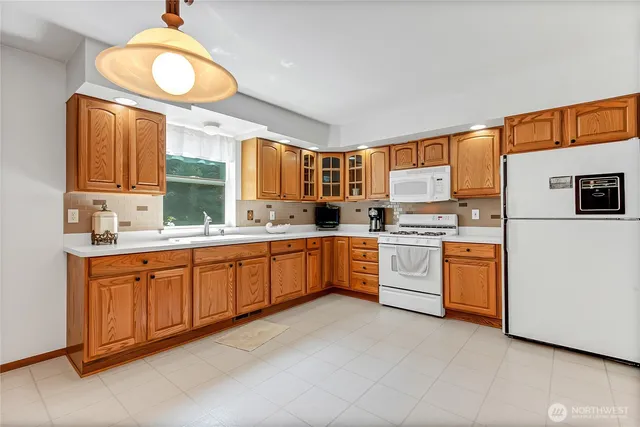 a kitchen with stainless steel appliances a sink cabinets and a window