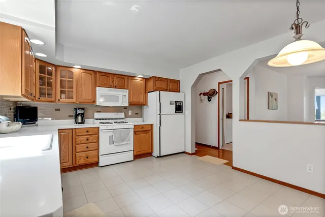 a kitchen with stainless steel appliances granite countertop a refrigerator and a stove top oven