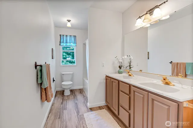 a spacious bathroom with a sink a toilet and a mirror