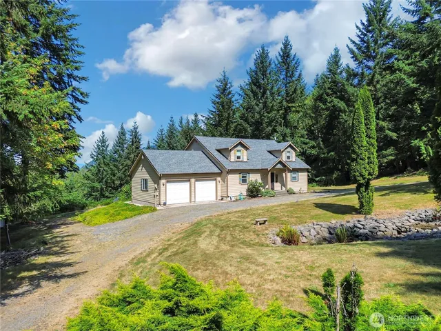 a view of a house with a big yard and large trees
