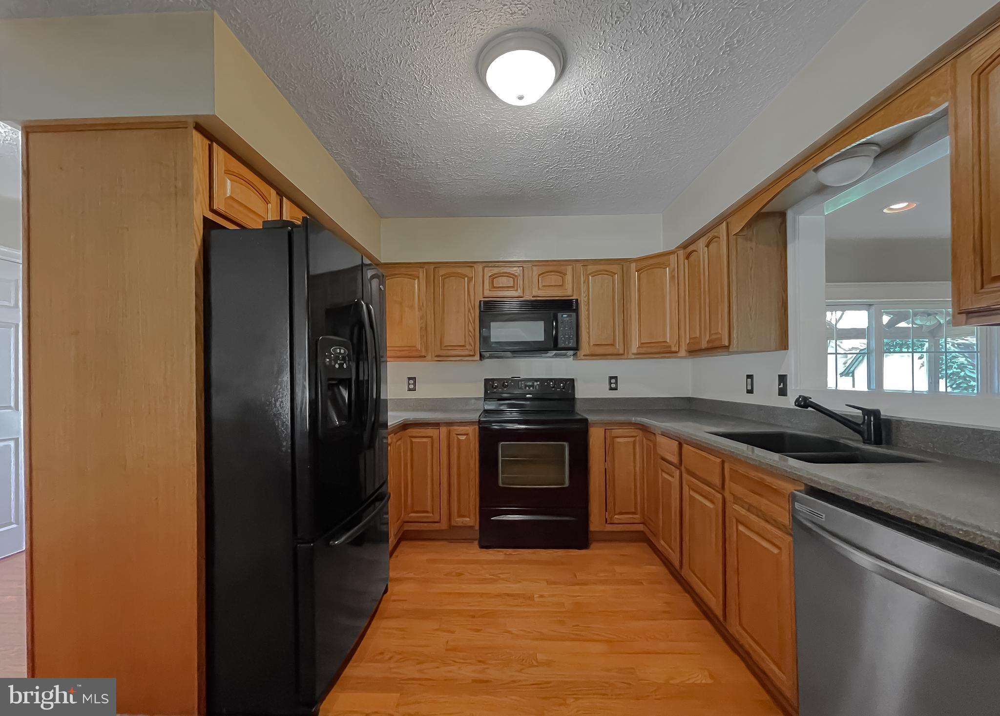 29799 Allen Road Mechanicsville, MD 20659 - Photo 9 of 49 a kitchen with stainless steel appliances granite countertop a refrigerator stove top oven and sink