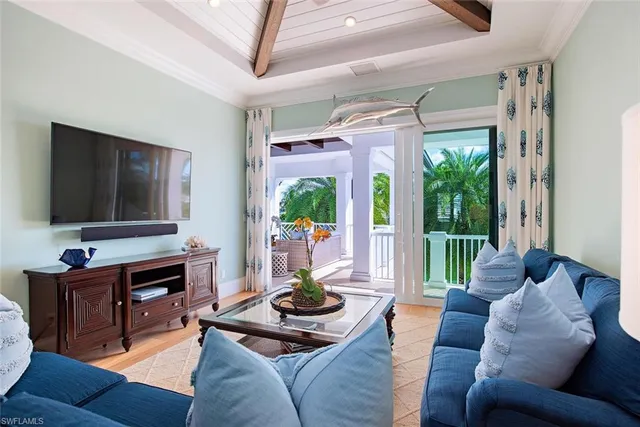 a living room with furniture a flat screen tv and a floor to ceiling window