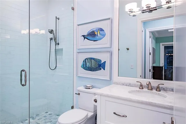 a bathroom with a granite countertop sink mirror vanity and toilet