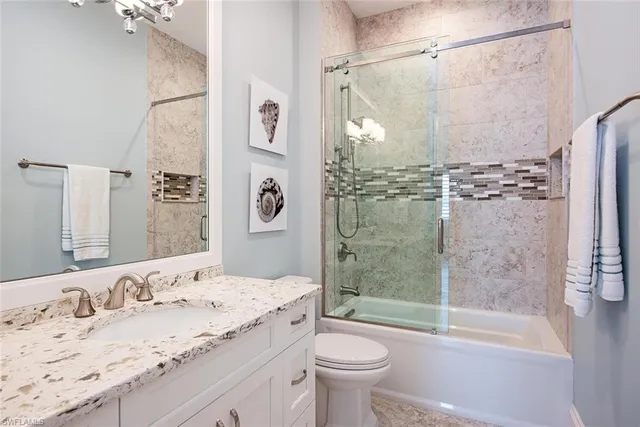 a bathroom with a granite countertop sink toilet and shower
