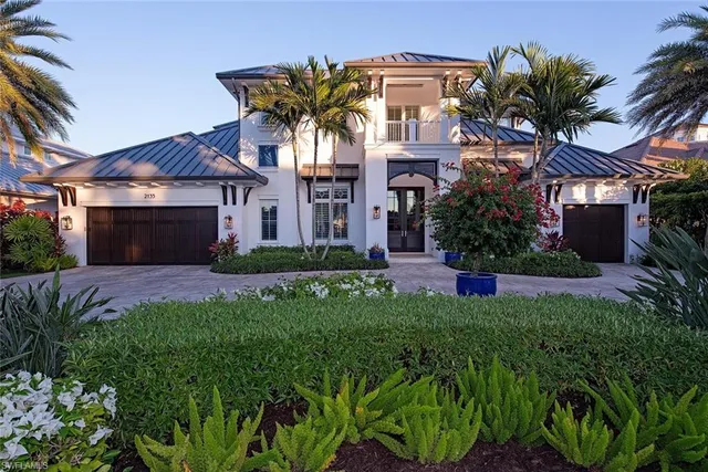 a front view of a house with a yard and potted plants