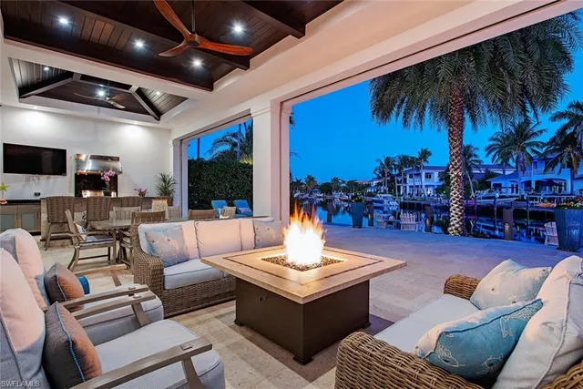 a living room with furniture and a large pool with table and chairs