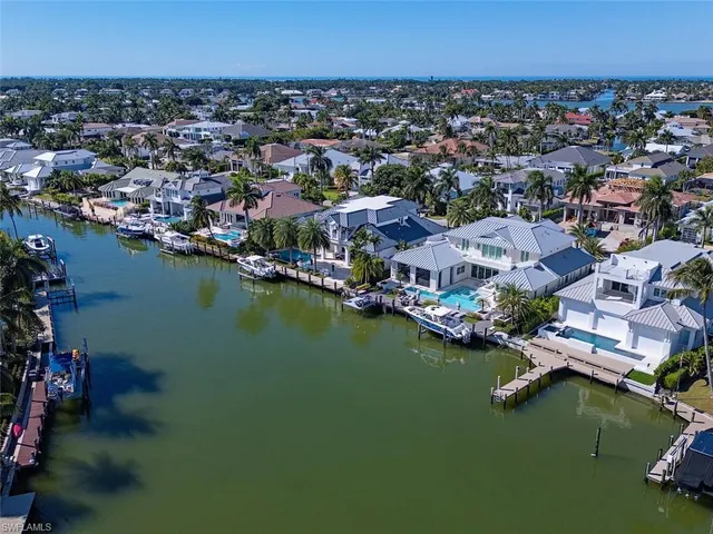 an aerial view of residential houses with outdoor space and lake view