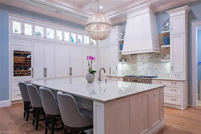 a view of kitchen island with granite countertop furniture a sink and stainless steel appliances