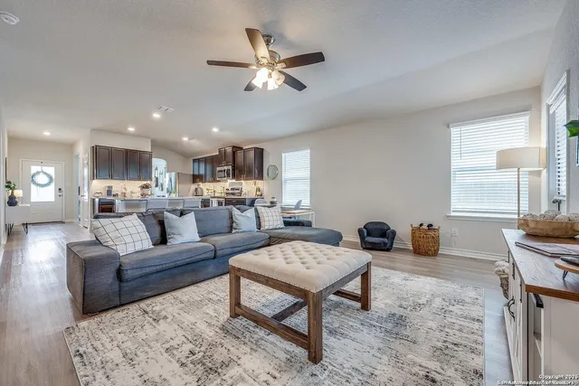 a living room with furniture and a view of kitchen