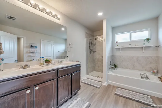 a bathroom with a tub a sink and mirror
