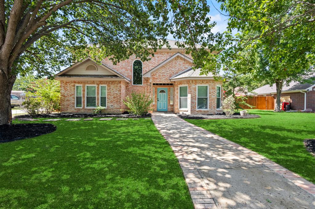 a front view of a house with a yard and trees