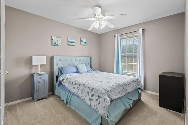 a bedroom with a large bed and a chandelier