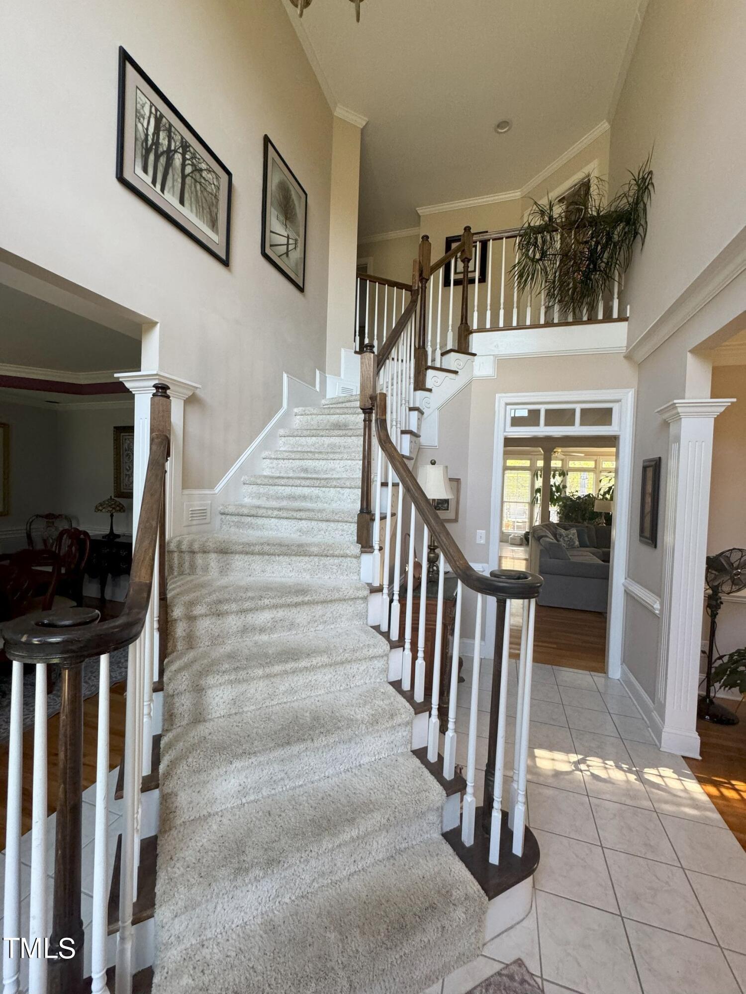 2212 Moss Pointe Lane Raleigh, NC 27606 - Photo 13 of 27 a view of staircase with lots of frames on wall and a flat screen tv