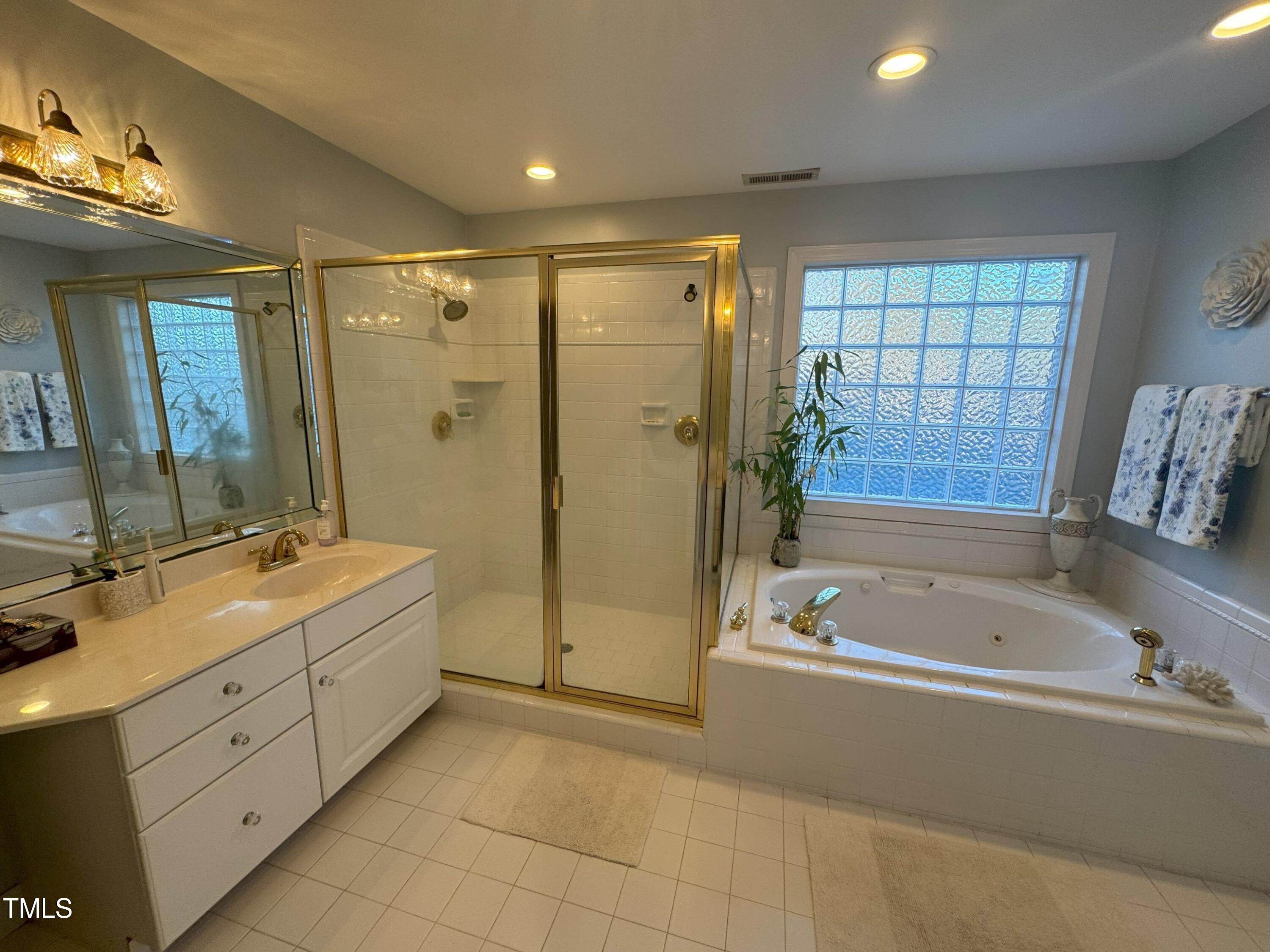2212 Moss Pointe Lane Raleigh, NC 27606 - Photo 16 of 27 a spacious bathroom with a tub sink shower and mirror