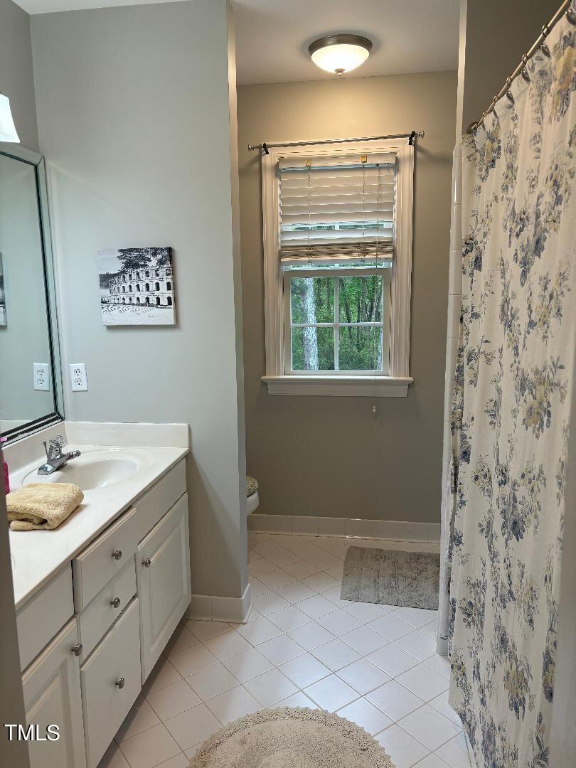 2212 Moss Pointe Lane Raleigh, NC 27606 - Photo 19 of 27 a bathroom with a granite countertop sink a mirror and shower