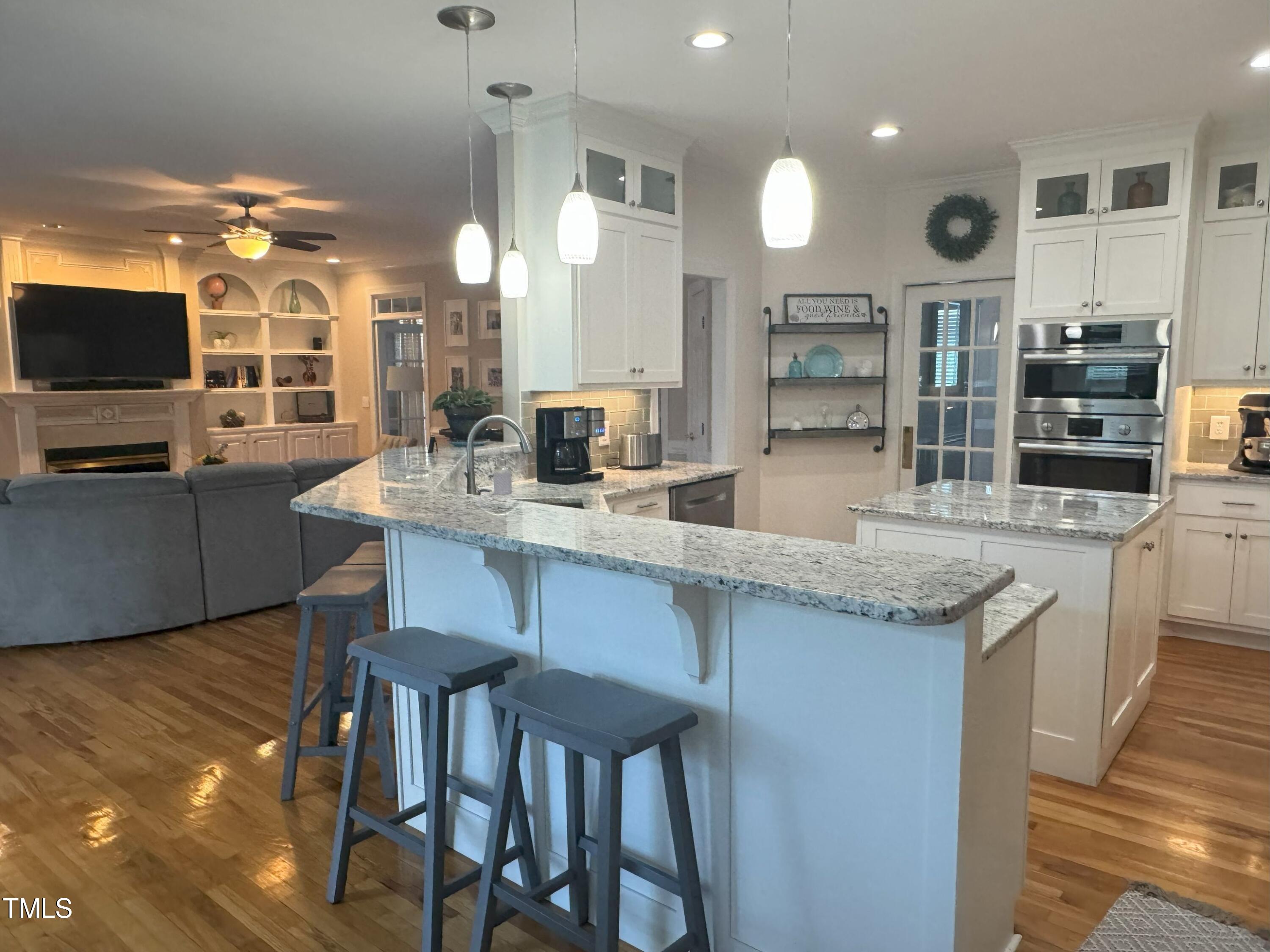 2212 Moss Pointe Lane Raleigh, NC 27606 - Photo 4 of 27 a kitchen with center island table and chairs
