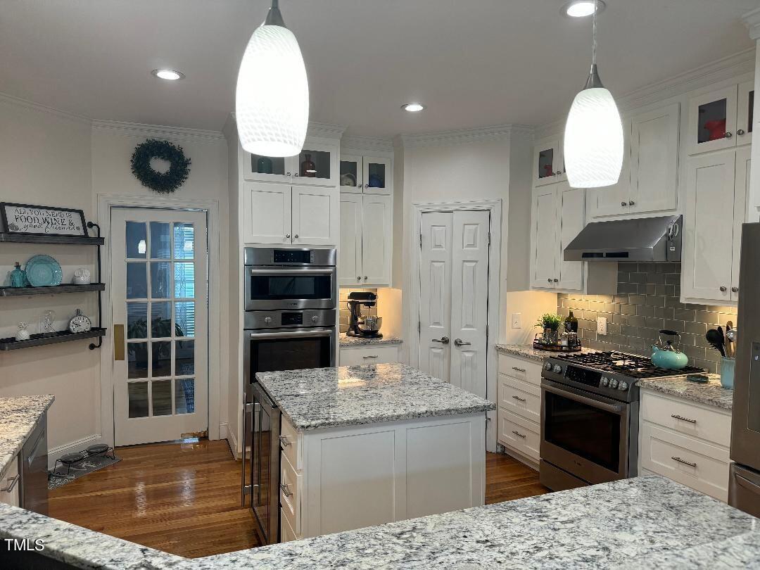 2212 Moss Pointe Lane Raleigh, NC 27606 - Photo 5 of 27 a kitchen with stainless steel appliances granite countertop a stove sink and cabinets