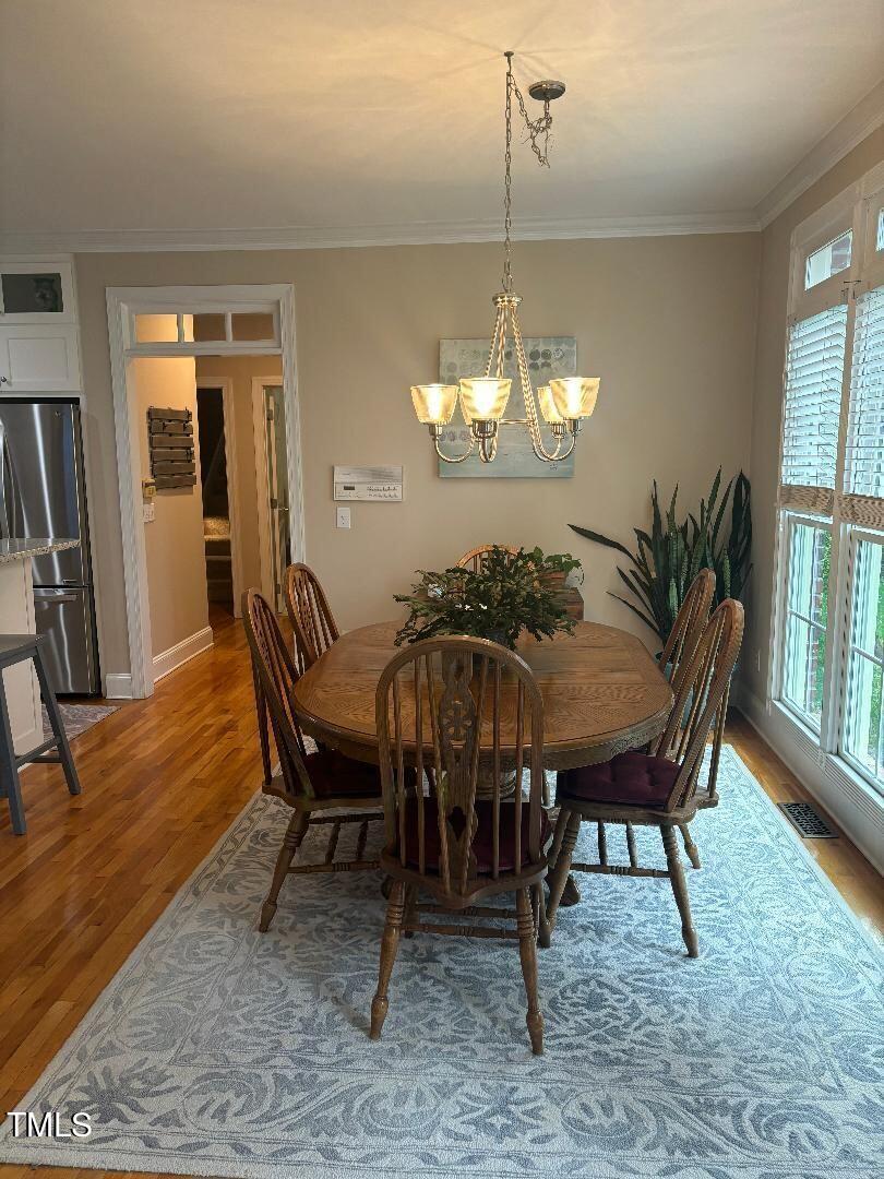2212 Moss Pointe Lane Raleigh, NC 27606 - Photo 7 of 27 a view of a dining room with furniture a chandelier and wooden floor