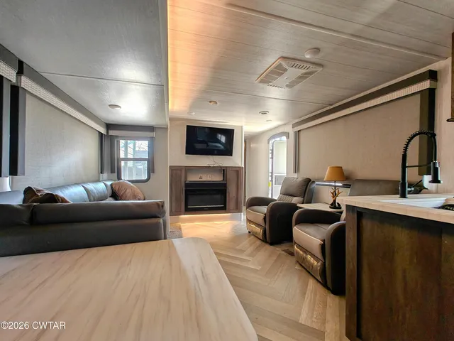 a living room with furniture a fireplace and a flat screen tv