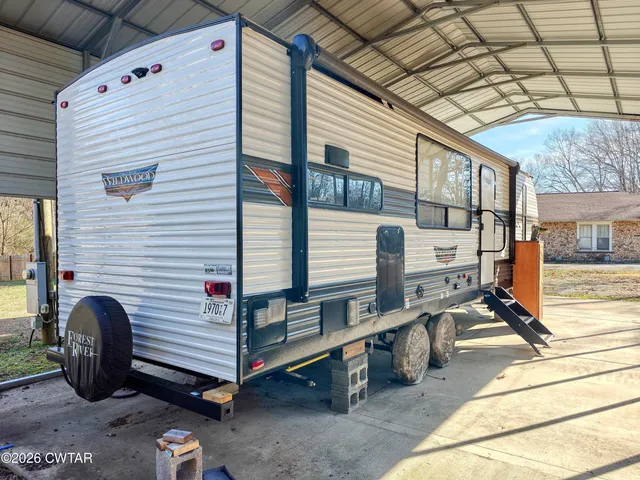 a backyard of a house with barbeque oven table and chairs
