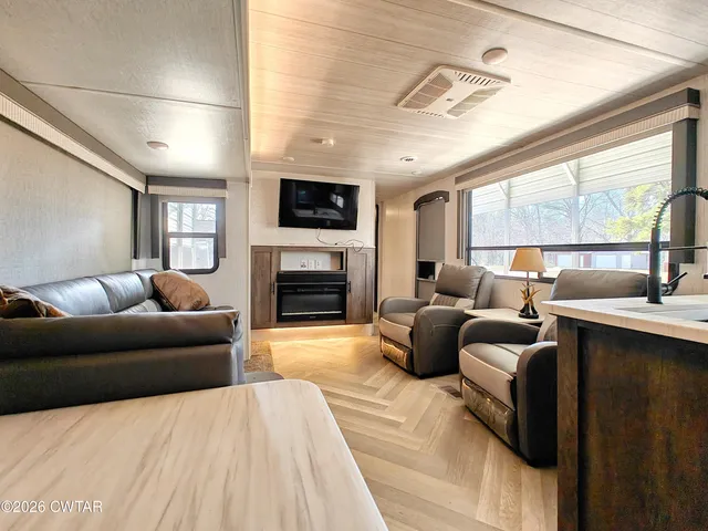 a living room with furniture a large window and a fireplace