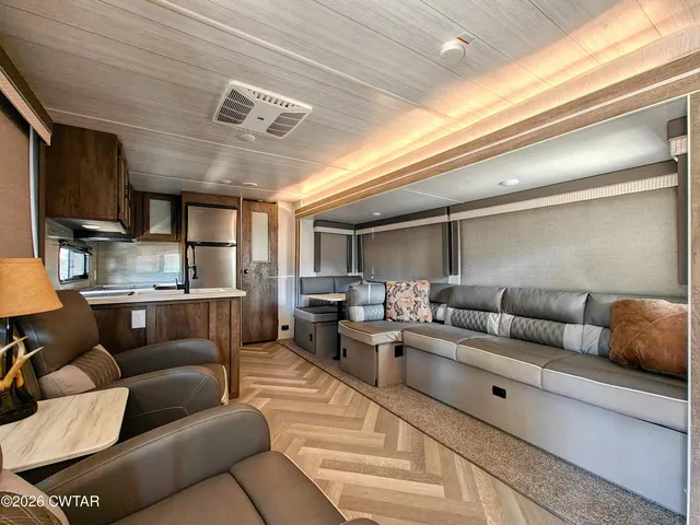a living room with furniture and a view of kitchen
