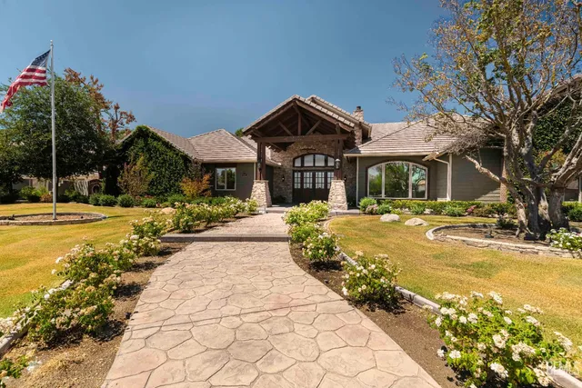 a view of swimming pool with lawn chairs under an umbrella