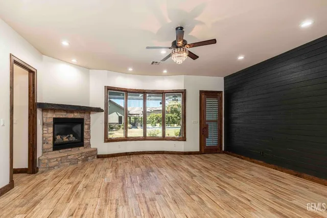 a view of swimming pool with outdoor seating and trees in the background
