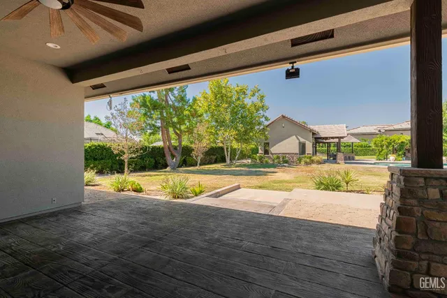a view of a patio with table and chairs under an umbrella