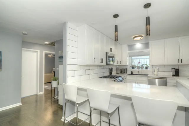 a kitchen with stainless steel appliances kitchen island granite countertop a sink and cabinets