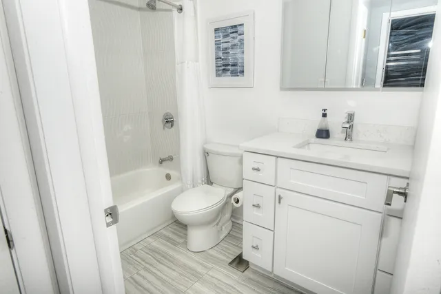 a bathroom with a granite countertop toilet a sink and a bathtub