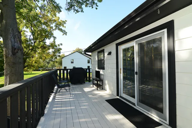a view of a balcony with wooden floor and floor to ceiling window and wooden fence