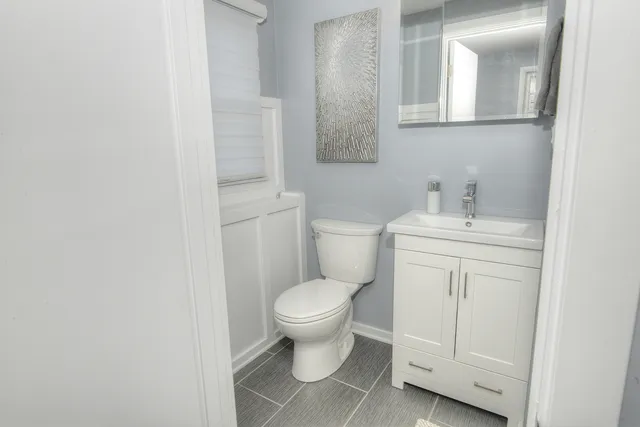 a bathroom with a toilet sink and mirror