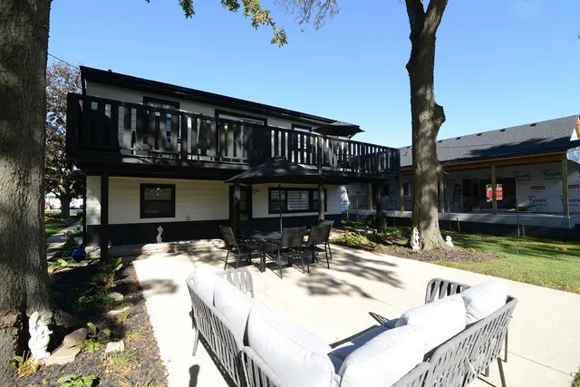 a backyard of a house with table and chairs